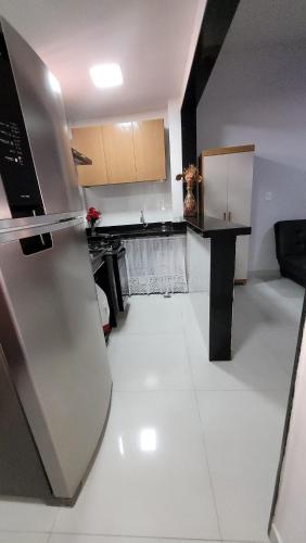 a kitchen with a stainless steel refrigerator in a room at Apto 1qt a 200mts da praia do Forte in Cabo Frio