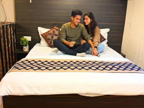 a man and woman sitting on a bed at Spatii Apartment in Rishīkesh