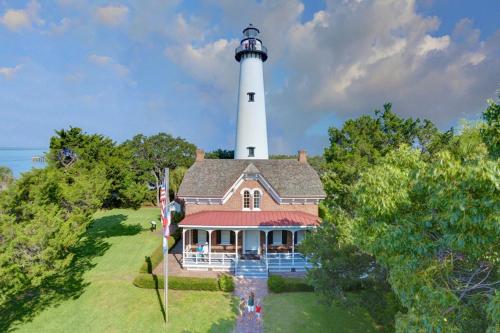 a house with a lighthouse on top of it at Central Condo, Community Pool and Gym, 10 Min to East Beach in Saint Simons Island