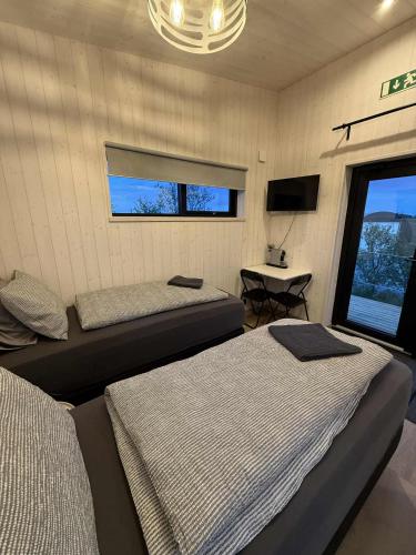 a bedroom with two beds and a table and a window at Gaddstaðir 32 in Hella