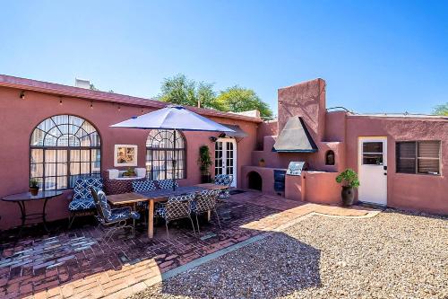 an outdoor patio with a table and an umbrella at Historic 3BD 2BA Tucson Bungalow, Steps to UofA in Tucson