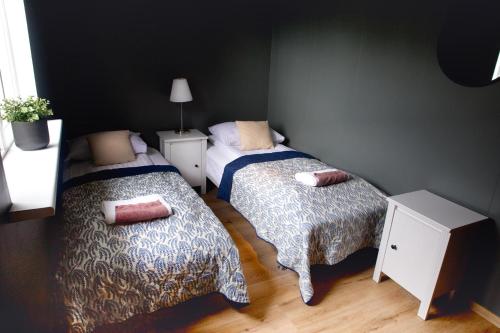 a small bedroom with two beds and a lamp at Efra Sel Hostel in Fludir