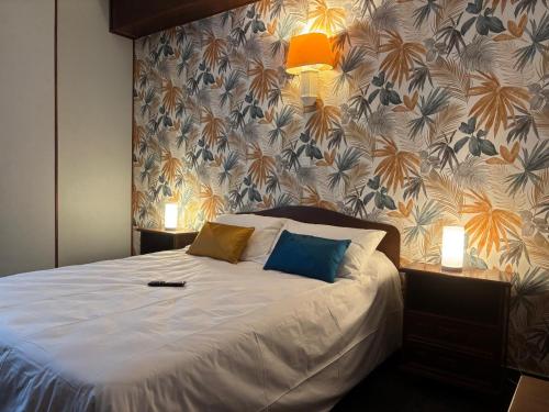 a bedroom with a bed with two pillows on it at Hôtel de Flandre in Compiègne