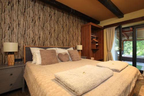 a bedroom with a large bed with two pillows at Spirit of the Earth Cottage Dobogókő in Pilisszentkereszt