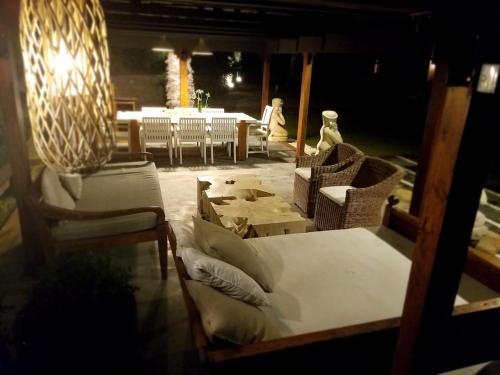 a patio with chairs and a bed and a table at Casa Bali Costa Brava in Palafrugell