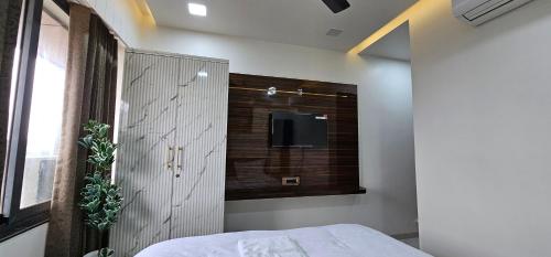 a bedroom with a bed and a tv on the wall at Hotel Rest in Ahmedabad