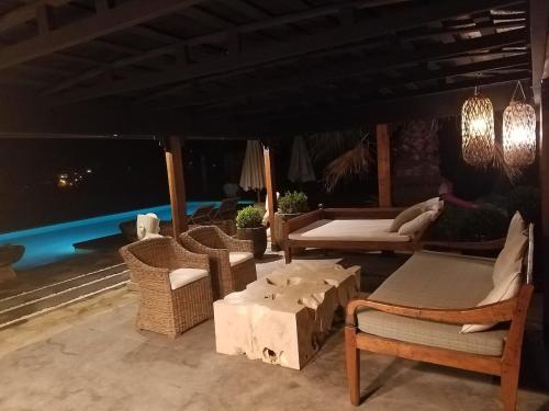 a patio with chairs and a table and a couch at Casa Bali Costa Brava in Palafrugell