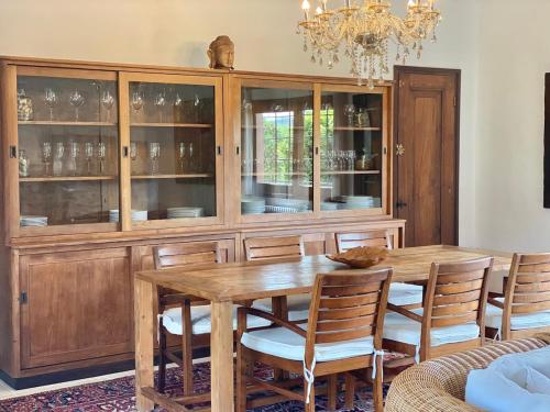 a dining room with a wooden table and a chandelier at Casa Bali Costa Brava in Palafrugell