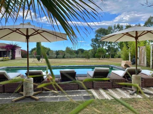 a swimming pool with umbrellas and chairs and a swimming pool at Casa Bali Costa Brava in Palafrugell