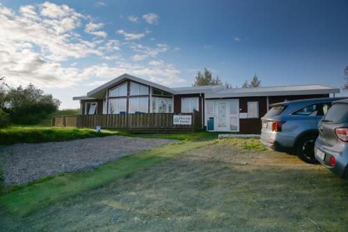 a house with two cars parked in front of it at Efra Sel Hostel in Fludir