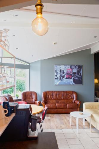 a living room with a leather couch and tables at Efra Sel Hostel in Fludir
