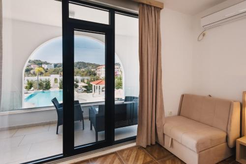 a living room with a table and a couch and a window at Apartments Stanaj in Ulcinj