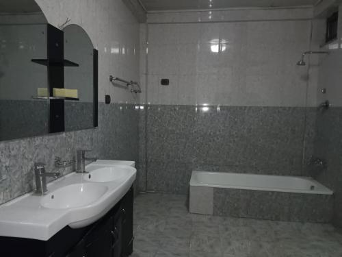a bathroom with two sinks and a bath tub at Grace Guest House in Addis Ababa