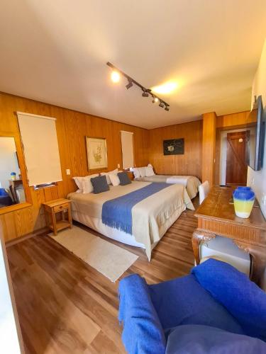 a large bedroom with two beds and a couch at Pousada Hortelã Village in Campos do Jordão