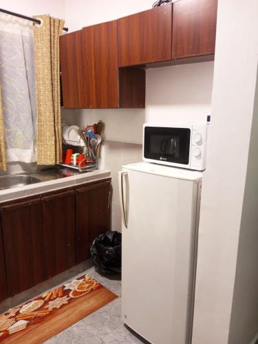 a kitchen with a microwave on top of a refrigerator at Kate's Ksm CBD apartments 3br2br1br O7Oo1FourFour22Eight in Kisumu