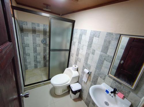 une salle de bains avec douche, toilettes et lavabo dans l'établissement Corcovado Paradise Lodge, à Drake