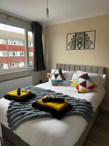 ein Schlafzimmer mit einem Bett mit Handtüchern darauf in der Unterkunft Bright and spacious home within walking distance to Luton Airport and amenities in Luton
