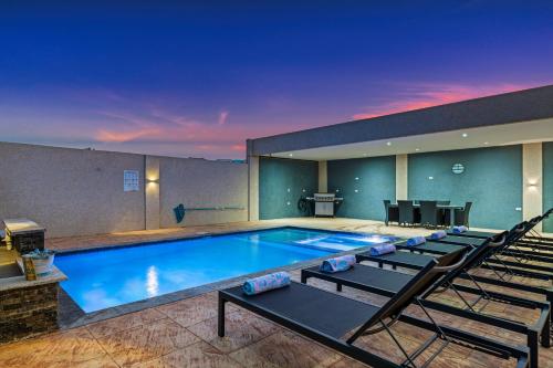a large swimming pool with chairs around it at Aruba Comfort Retreat 2br W Pool, Bbq & Gated in Pos Abao