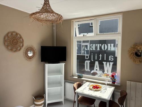 a dining room with a table and a window at Hotel B&B Altijd Wad in West-Terschelling