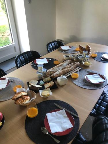 a wooden table with plates of food on it at Le domaine de la Belle Demeure Chambre et table d hôte in Saint-Genès-du-Retz