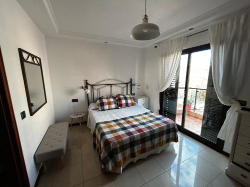 a bedroom with a bed and a large window at Duplex El Principito in Gran Tarajal