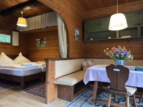 a room with a table and a bed and a table and chairs at Blockhaus mitten in der Natur in Eschede