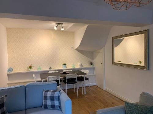 a living room with a blue couch and a table at The Rossiter - City Centre Pad in Bath