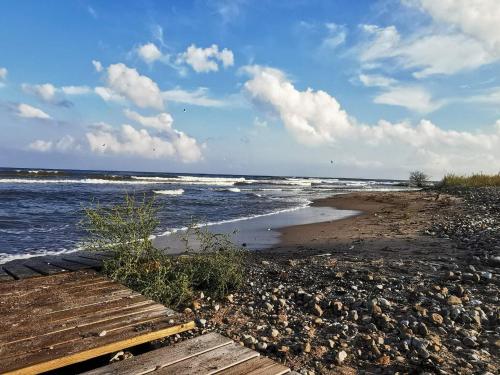 a beach with rocks and the ocean with waves at 6 person holiday home in Ljugarn-By Traum in Ljugarn