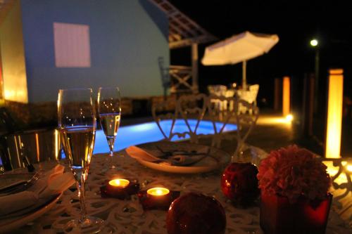 a table with two glasses of wine and candles at Biz & Biu Pousada Lavras Novas in Lavras Novas