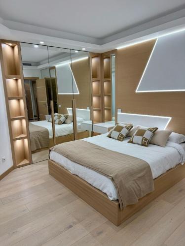 une chambre avec un grand lit et un grand miroir dans l'établissement Luxury Apartment in the heart of Principality of Monaco, à Monte-Carlo