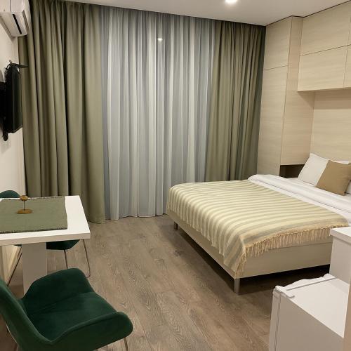 a bedroom with a bed and a desk and a chair at Batumi Gonio Apartment 50m to Sea, Pool & Sauna in Gonio