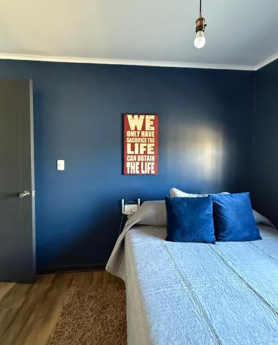 a bedroom with blue walls and a bed with blue pillows at Linda casa en sector Las rastras Talca in Talca