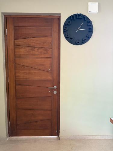 a wooden door and a clock on a wall at Linda casa en sector Las rastras Talca in Talca