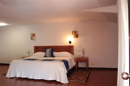 1 dormitorio con 1 cama con sábanas blancas y azules en Hotel Ilebal Cuernavaca Centro - lugar con encanto!, en Cuernavaca
