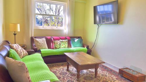 a living room with a couch and a table at Pousada Hortelã Village in Campos do Jordão