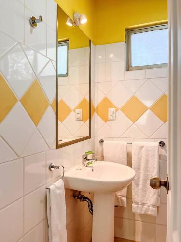 a bathroom with a sink and a mirror and towels at Sueño al Mar Residence & Hotel in Potrero
