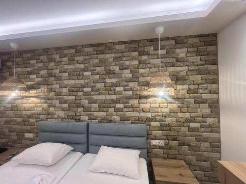 a bedroom with a brick wall and a bed at Dolphin Hotel Apartments in Karpathos Town