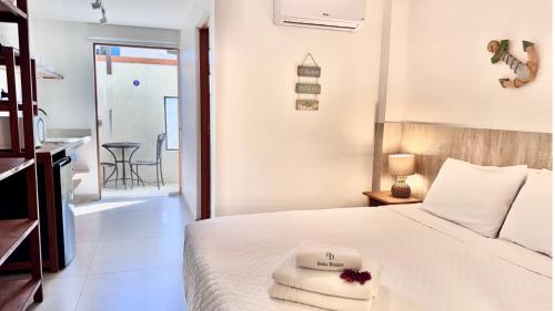 a bedroom with a bed with towels on it at Bella Buzios Apartamentos in Búzios