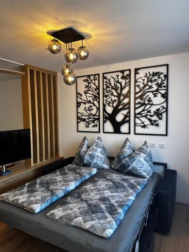 two beds in a room with paintings on the wall at Alpenblick - Ferienwohnung Vockner in Strobl