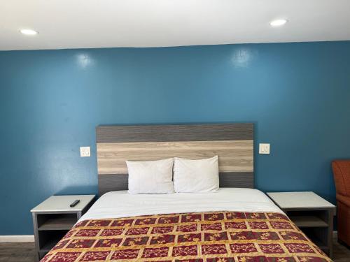 a bedroom with a bed with a blue wall at Anaheim National Inn in Anaheim