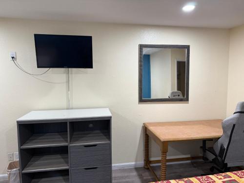 a room with a desk and a tv on a wall at Anaheim National Inn in Anaheim