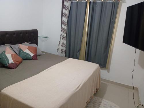 a bedroom with a bed and a window with curtains at Casa Cop30 Belém in Belém