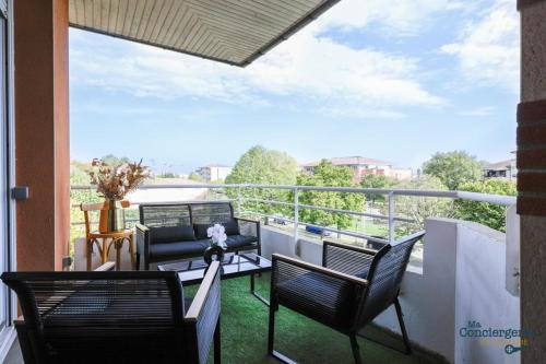 einen Balkon mit 2 Stühlen und einem Sofa in der Unterkunft Montaigne - Proche Tram - 5min Aéroport in Blagnac
