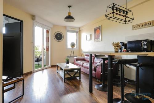 ein Wohnzimmer mit Sofa und Tisch in der Unterkunft Montaigne - Proche Tram - 5min Aéroport in Blagnac