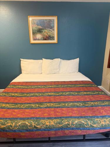 a bedroom with a bed with a colorful blanket at Anaheim National Inn in Anaheim