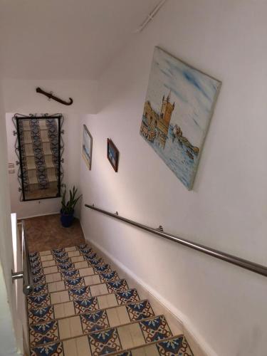 a stairway with a painting on the wall at Dar Ba à 15 min à pied de la mer in Essaouira
