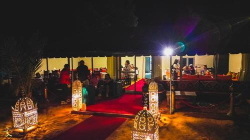 a stage with a red carpet and lights in a room at Dounia Luxury Camp in Merzouga