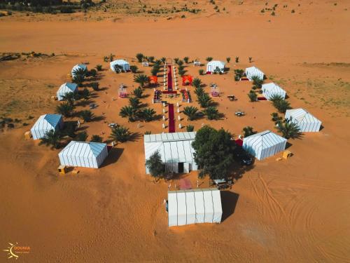 an aerial view of a desert with a mosque at Dounia Luxury Camp in Merzouga