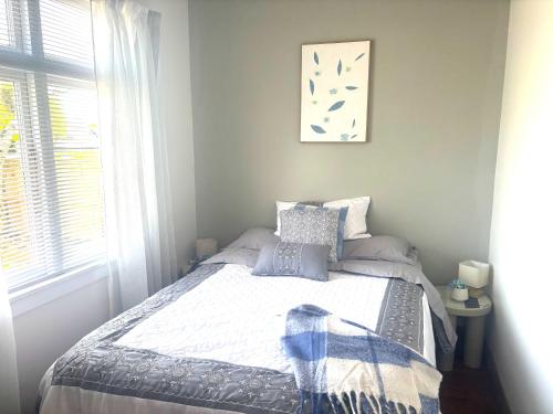 a bedroom with a bed and a window at Cute and Central in Rotorua