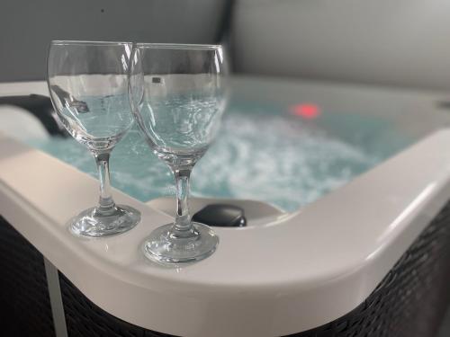 two wine glasses sitting on top of a bath tub at Private Spa and Garden 10 min from Mont St-Michel in Pontorson
